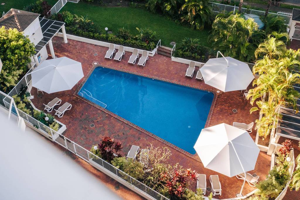 Outdoor pool with loungers and umbrellas at The Crest