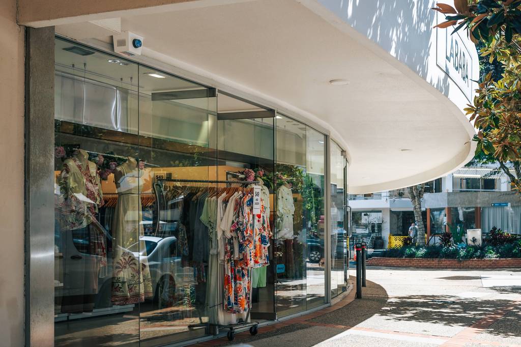 Fashion retail storefront with curved glass window beneath white curved awning