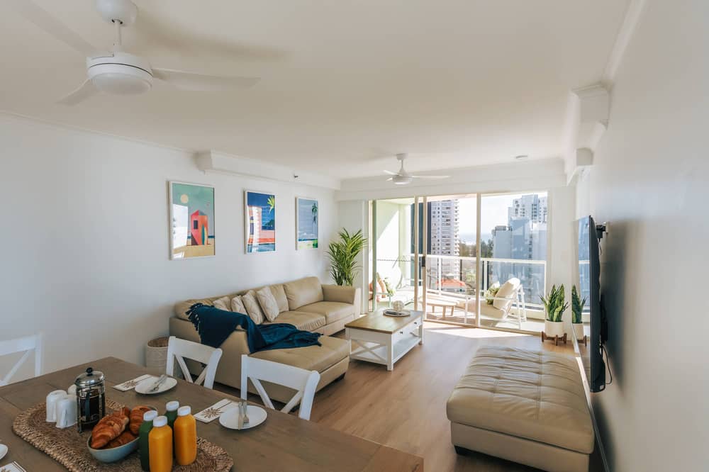 Living area with beige sofa and high-rise balcony views