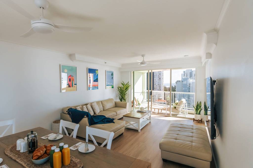 Living area with beige sofa and high-rise balcony views